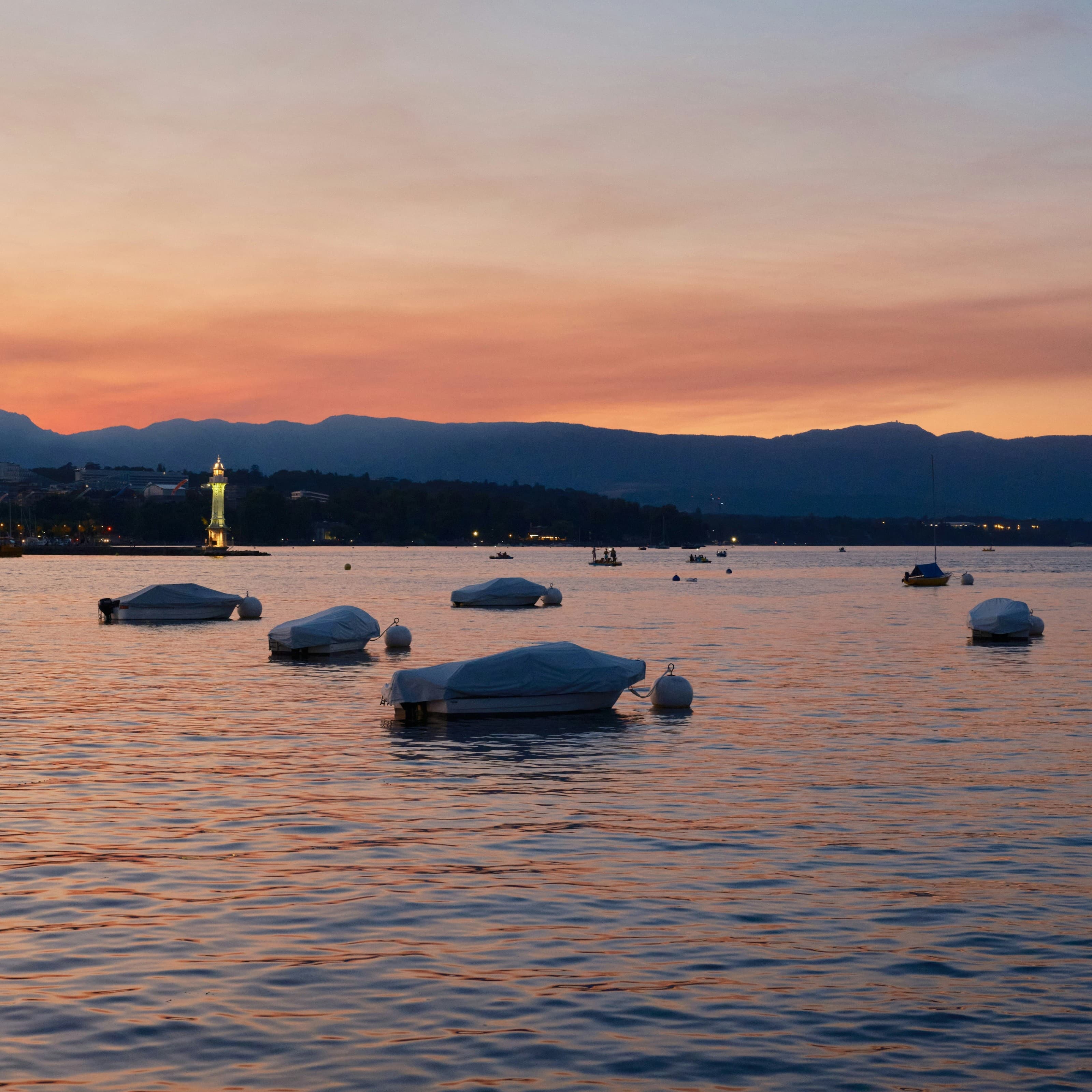 La rade de Genève au couchant, bateaux bâchés et phare des Pâquis